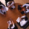 5 Personen sitzen an einem Tisch und diskutieren